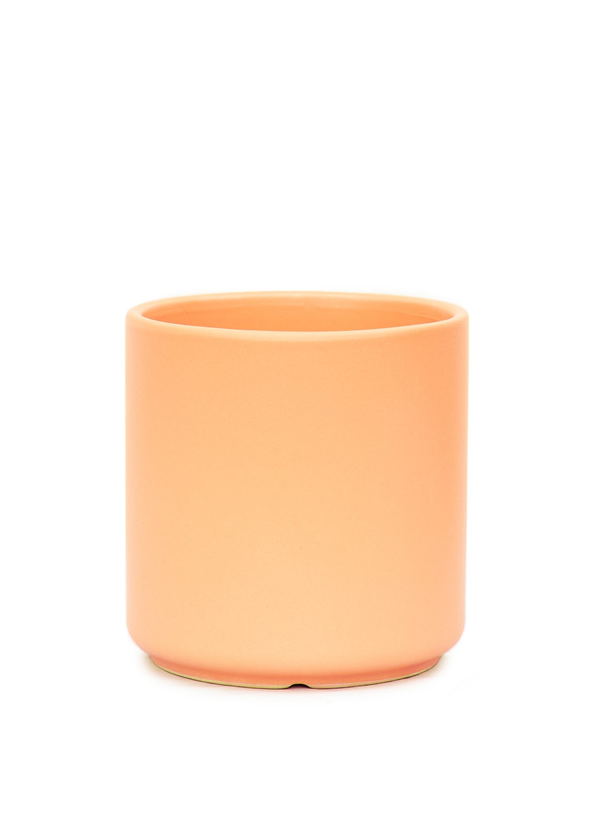 Elegant cylinder ceramic planter showcasing its smooth finish and minimalist design - in Peach.